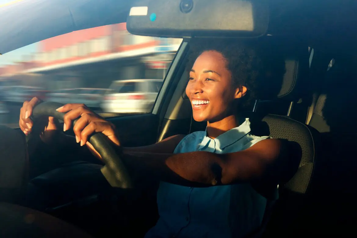 A woman driving in the car with a banana peel on her steering wheel.