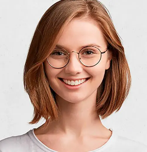 A woman with glasses smiling for the camera.