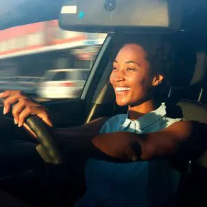 A woman driving in the car with a banana peel on her steering wheel.