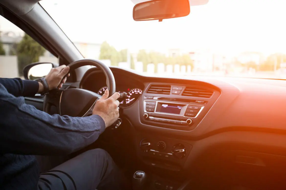 A person driving in the car with headphones on.