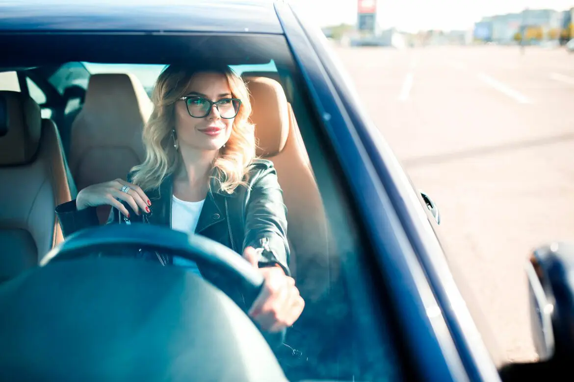 A woman driving in her car on the road.