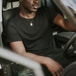 A man sitting in the driver 's seat of his car.