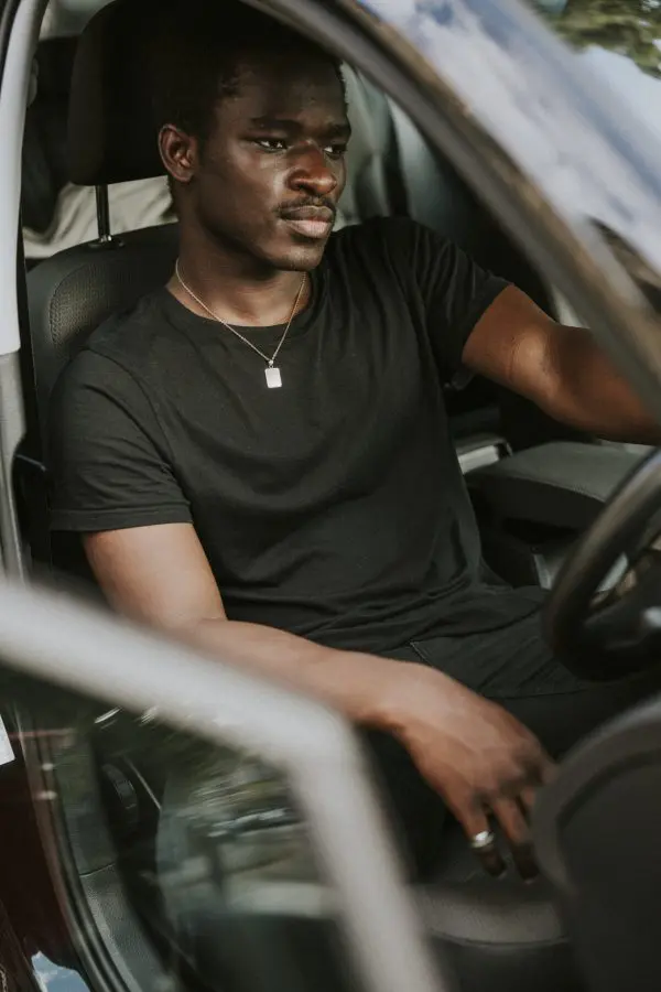 A man sitting in the driver 's seat of his car.