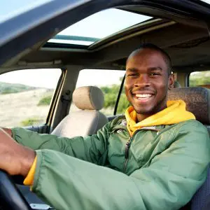 A man sitting in the driver 's seat of his car.