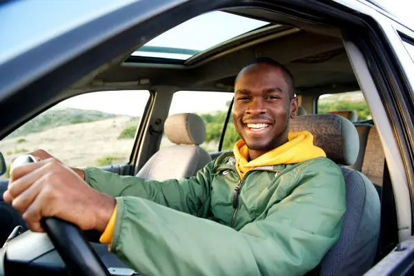 A man sitting in the driver 's seat of his car.