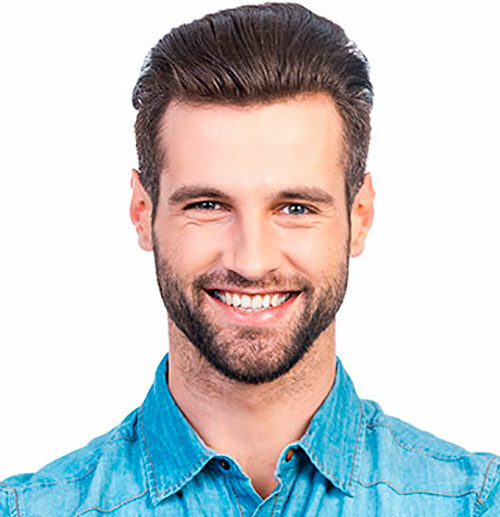 A man with beard and blue shirt smiling for the camera.