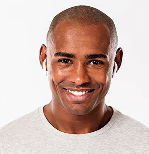 A man with a shaved head smiling for the camera.