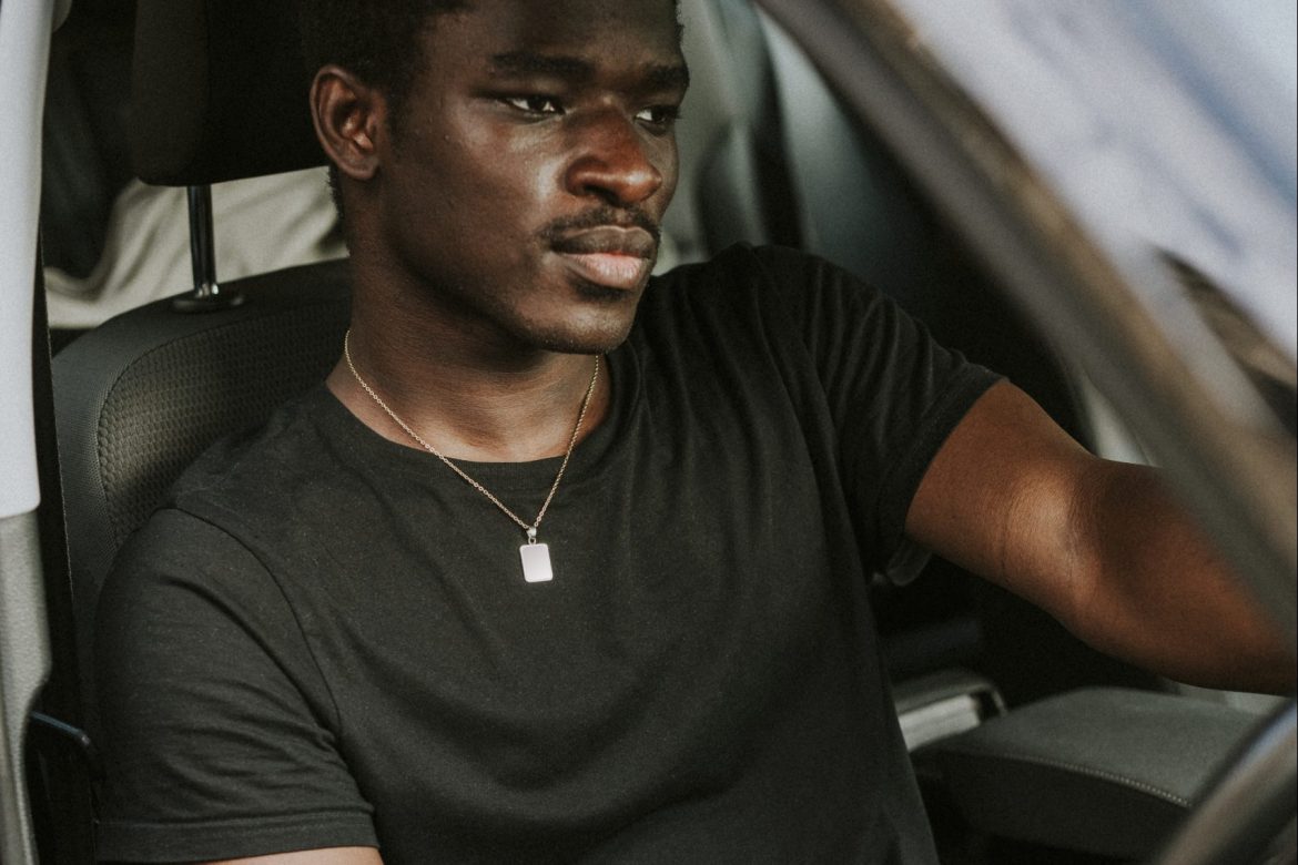 A man sitting in the driver 's seat of his car.